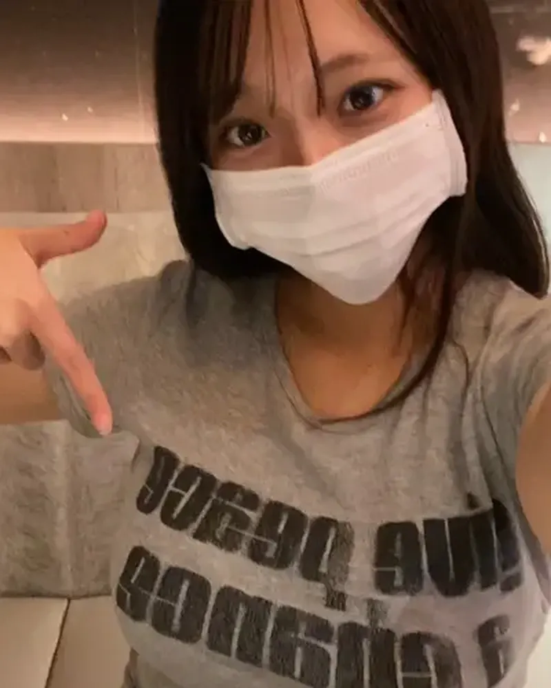 Shinsotsu-chan in a grey T-shirt and white face mask, pointing at the camera (her MyFans profile photo)