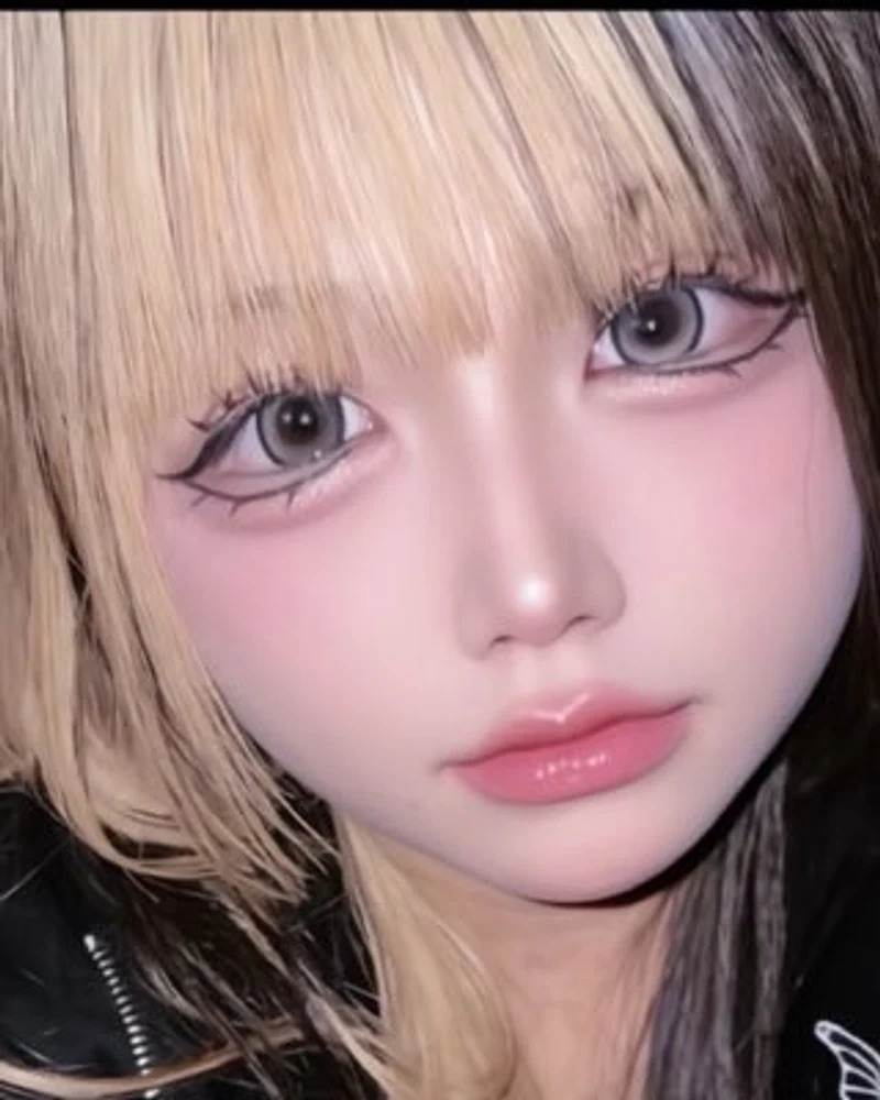 Close-up portrait of Tsuki with blonde hair and bold eye make-up (photo from her X account)