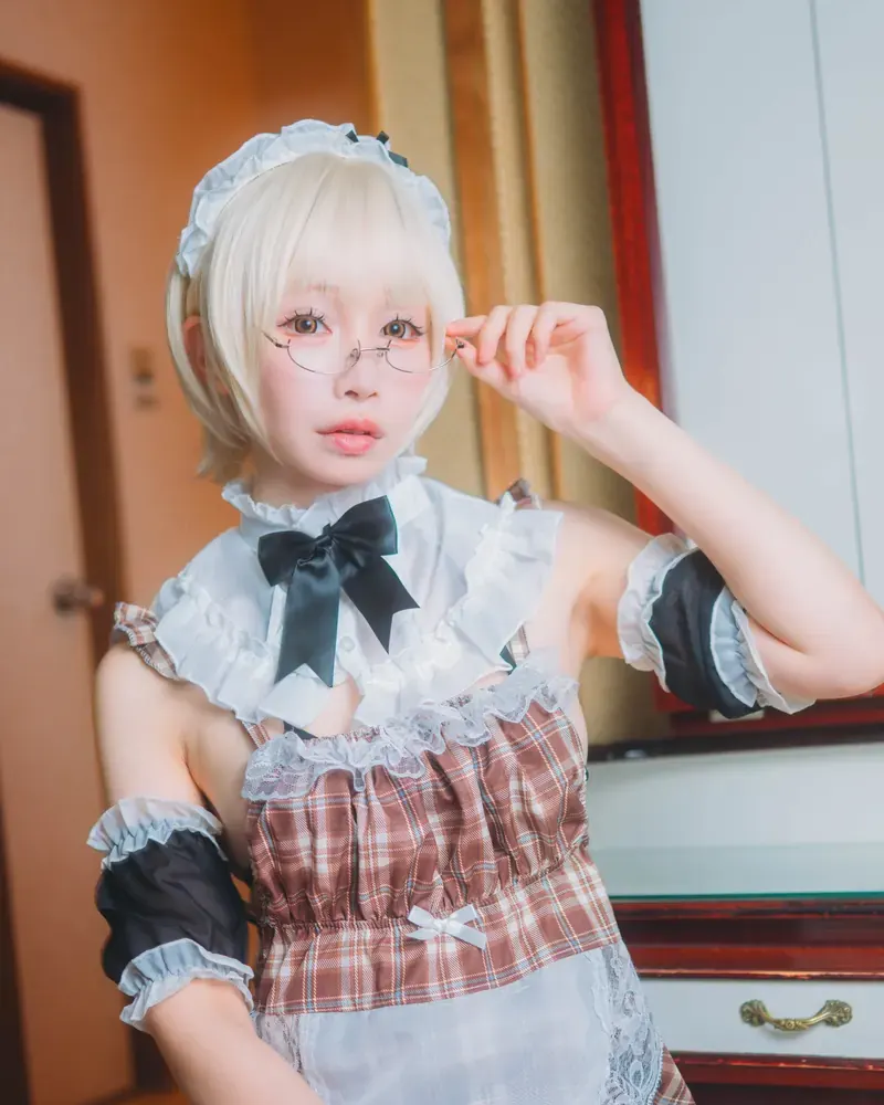 Yuzumiya in a maid cosplay with round glasses (creator-provided photo)